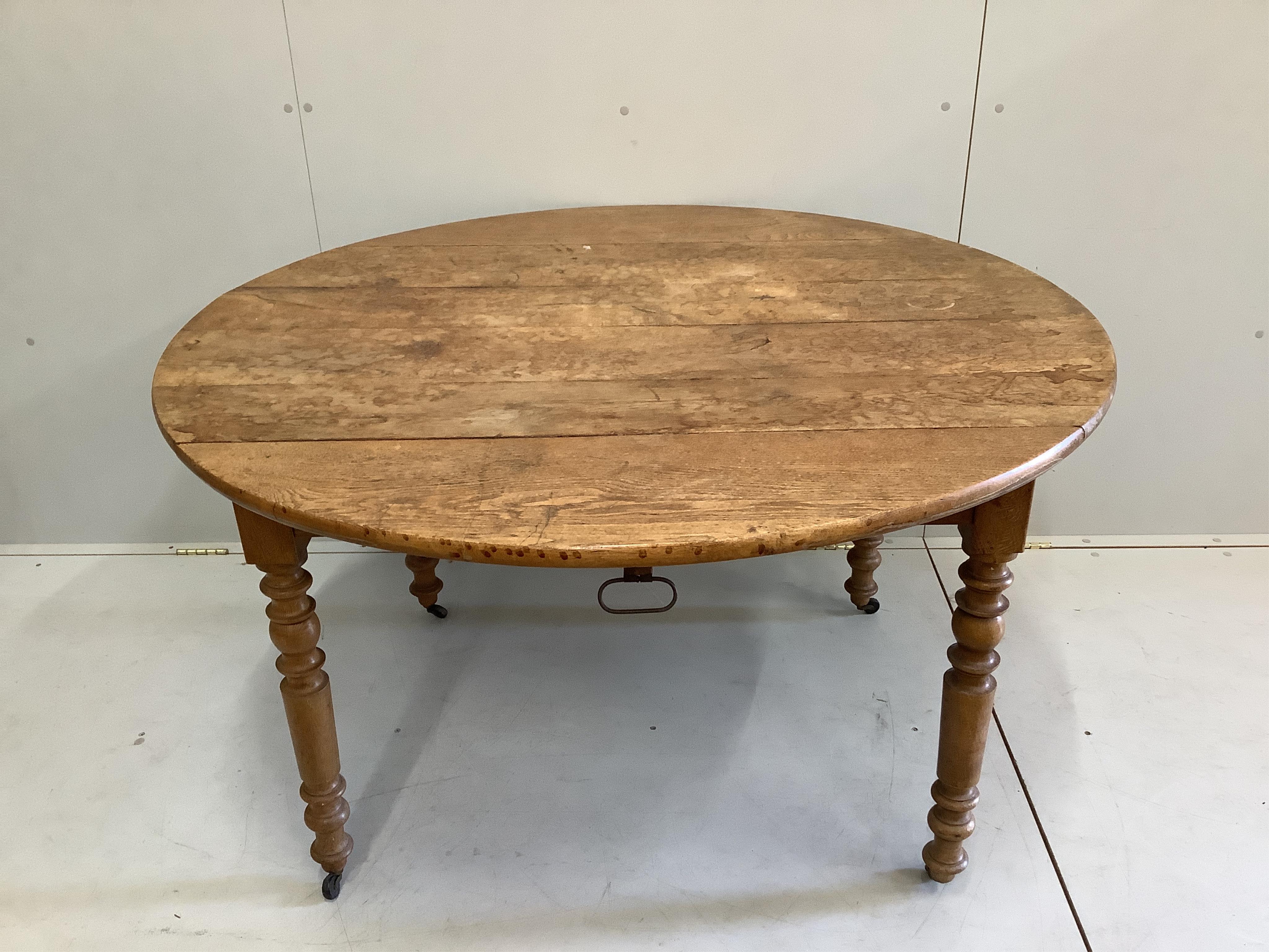A 19th century French oak drop flap dining table, width 124cm, depth 76cm, height 73cm
